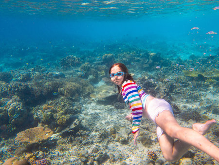 Child snorkeling. Kids swim underwater. Beach and sea summer vacation with children. Little girl watching coral reef fish. Marine life on exotic island. Kid swimming and diving with snorkel and mask.の写真素材