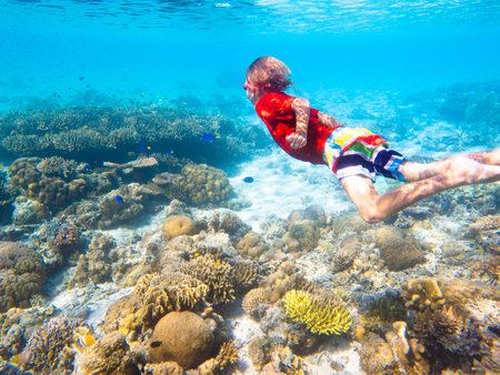 Child snorkeling. Kids swim underwater. Beach and sea summer vacation with children. Little girl watching coral reef fish. Marine life on exotic island. Kid swimming and diving with snorkel and mask.の写真素材
