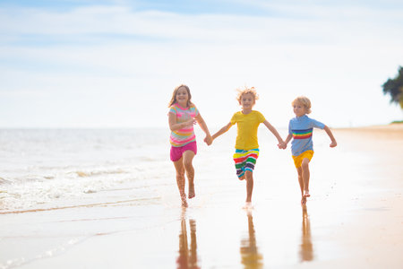 Child playing on tropical beach. Little boy with bucket and spade at sea shore. Family summer vacation. Kid building sandcastle. Water and sand fun for children. Kids play, build castle on ocean coastの写真素材