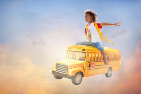Child going back to school. Boy flying on school bus. Imagination and creative mind. Happy little...