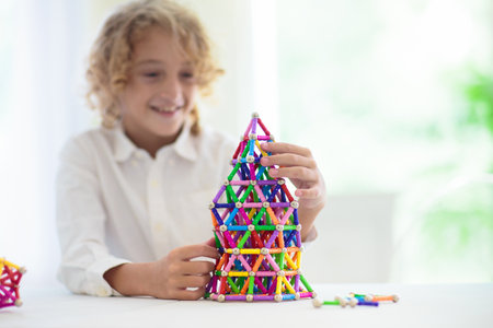 Child playing with magnetic sticks and balls building blocks. Little boy building tower. Educational toys for kids. Construction toys for young children. Geometry and math game. preschool fun.の写真素材