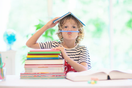 Child doing homework at home. Little kid with colorful books reading and doing math exercise. Kids study and learn. School kid with book writing and reading. back to school.の写真素材
