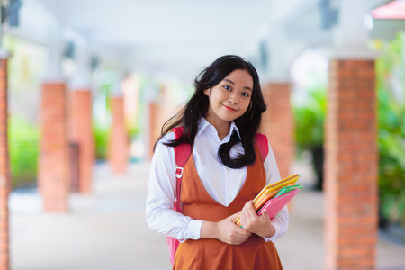 Kids go back to school. Asian teenager student with backpack and books on the first day of new academic year. Start of middle or high school. Teen pupil in school yard.の写真素材