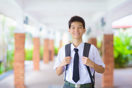 Kids go back to school. Asian teenager student with backpack and books on the first day of new...