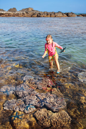 Child snorkeling. Kids swim and watch marine life. Beach and sea summer vacation with children. Little kid watching coral reef fish. Holiday on exotic island. Kid swimming and diving.の写真素材