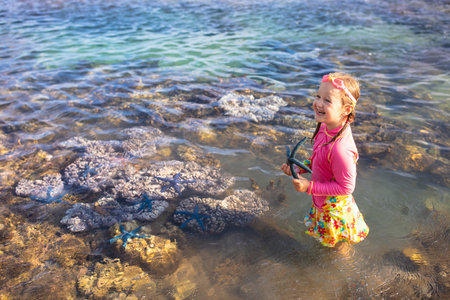 Child snorkeling. Kids swim and watch marine life. Beach and sea summer vacation with children. Little kid watching coral reef fish. Holiday on exotic island. Kid swimming and diving.の写真素材