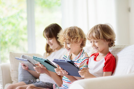Kids with mobile phone. Child with tablet computer watching movie or playing game. Group of little...