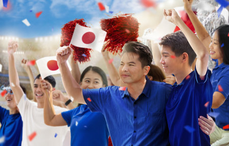 Japan football supporter on stadium. Japanese fans on soccer pitch watching team play. Group of supporters with flag and national jersey cheering for Japan. Championship game.の写真素材