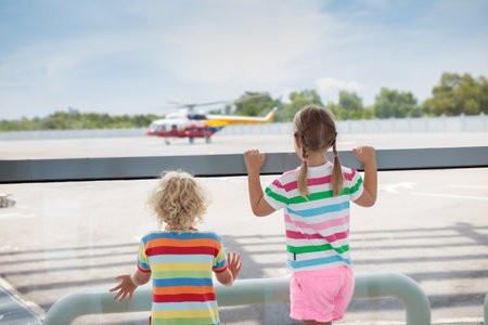 Kids at airport. Children look at airplane. Traveling and flying with child. Family at departure gate. Vacation and travel with young kid. Child before flight in terminal. Kids fly a plane.の写真素材