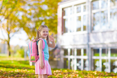 Child going back to school. Start of new school year after summer vacation. Little girl with backpack and books on first school day. Beginning of class. Education for kindergarten and preschool kids.の写真素材