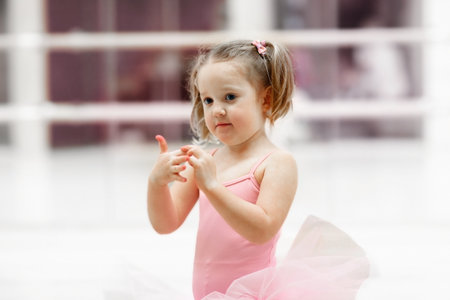 Little ballerina girl in a pink tutu. Adorable child dancing classical ballet in a white studio. Children dance. Kids performing. Young gifted dancer in a class. Preschool kid taking art lessons.の写真素材