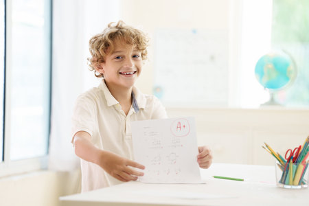 Child holding school test with excellent A grade. Student happy after exam. Little boy with A note...