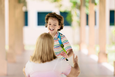 Child happy to be back to school. End or start of summer vacation for school kids. Excited happy little boy with backpack running on school yard. Student on his way home.の写真素材