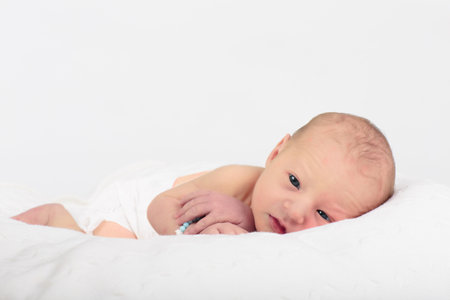 Newborn baby in hospital room. New born child in wooden co-sleeper crib. Infant sleeping in bedside bassinet. Safe co-sleeping in a bed side cot. Little boy taking a nap under knitted blanket.の写真素材