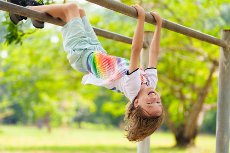 Child on playground. Active kid exercising in school yard. Children play and climb. Little boy on...