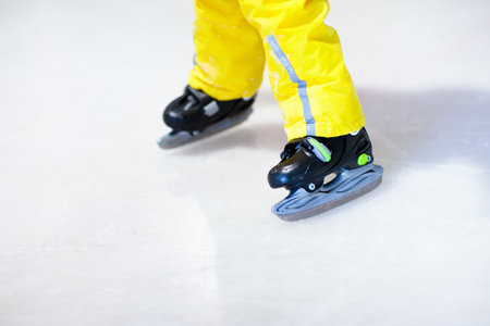 Child skating on indoor ice rink. Kids skate. Active family sport during winter vacation and cold season. Little boy in colorful wear training or learning ice skating. School sport activities and clubsの写真素材