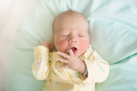 Newborn baby in hospital room on nursing pillow. New born child in crib. Hungry infant in bedside bassinet. Little boy just after birth after bath and examination.の写真素材