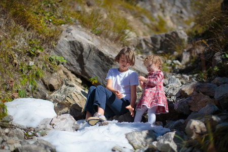 Family with kids hiking in the mountains. Young children hike in beautiful Alps mountain landscape. Travel with baby. Trekking and camping with young child. Outdoor adventure.の写真素材