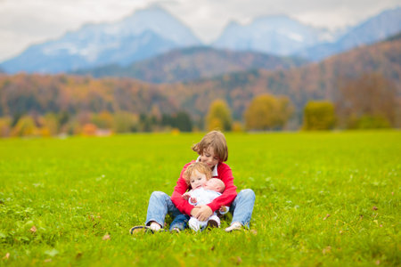 Family with kids in the mountains. Young mother and children in beautiful Alps mountain landscape. Travel with baby. Trekking and camping with young child. Outdoor adventure.の写真素材