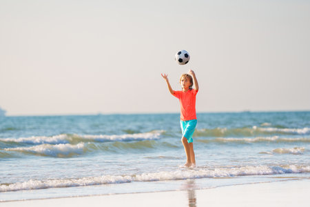 Kids playing on tropical beach. Children swim and play at sea on summer family vacation. Sand and water fun, sun protection for young children. Little boy running and jumping at ocean shore.の写真素材
