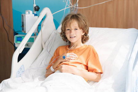 Sick child in hospital room. Kid in clinic ward. Little boy with oxygen tube and IV line in hospital bed. Pediatrician doctor examining patient. Family health care and insurance. Medicine for children.の写真素材