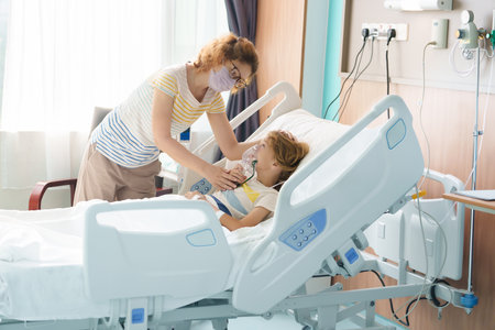 Sick child in hospital room. Kid in clinic ward. Little boy with oxygen tube and IV line in hospital bed. Pediatrician doctor examining patient. Family health care and insurance. Medicine for children.の写真素材