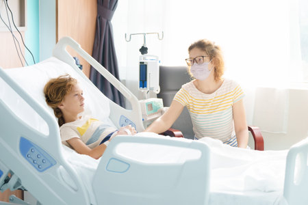 Sick child in hospital room. Kid in clinic ward. Little boy with oxygen tube and IV line in hospital bed. Pediatrician doctor examining patient. Family health care and insurance. Medicine for children.の写真素材