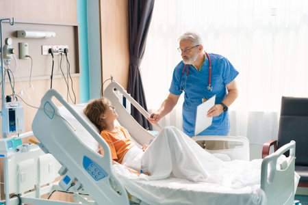 Sick child in hospital room. Kid in clinic ward. Little boy with oxygen tube and IV line in hospital bed. Pediatrician doctor examining patient. Family health care and insurance. Medicine for children.の写真素材