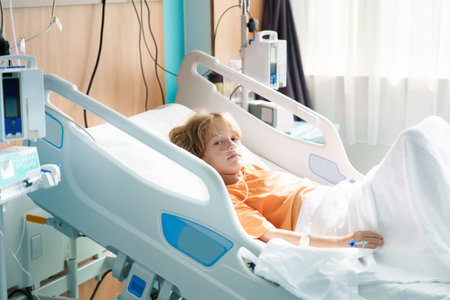 Sick child in hospital room. Kid in clinic ward. Little boy with oxygen tube and IV line in hospital bed. Pediatrician doctor examining patient. Family health care and insurance. Medicine for children.の写真素材