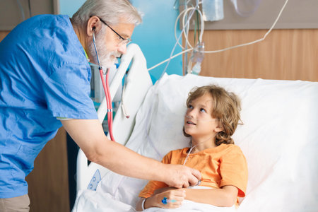 Sick child in hospital room. Kid in clinic ward. Little boy with oxygen tube and IV line in hospital bed. Pediatrician doctor examining patient. Family health care and insurance. Medicine for children.の写真素材