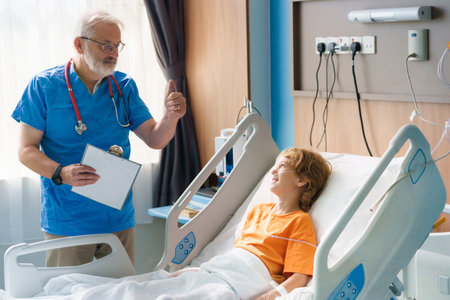 Sick child in hospital room. Kid in clinic ward. Little boy with oxygen tube and IV line in hospital bed. Pediatrician doctor examining patient. Family health care and insurance. Medicine for children.の写真素材