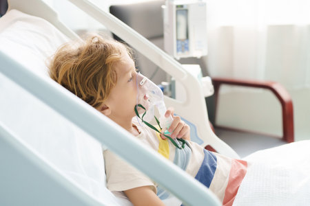 Sick child in hospital room. Kid in clinic ward. Little boy with oxygen tube and IV line in hospital bed. Pediatrician doctor examining patient. Family health care and insurance. Medicine for children.の写真素材