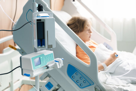 Sick child in hospital room. Kid in clinic ward. Little boy with oxygen tube and IV line in hospital bed. Pediatrician doctor examining patient. Family health care and insurance. Medicine for children.の写真素材