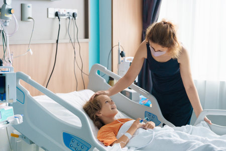 Sick child in hospital room. Kid in clinic ward. Little boy with oxygen tube and IV line in hospital bed. Pediatrician doctor examining patient. Family health care and insurance. Medicine for children.の写真素材