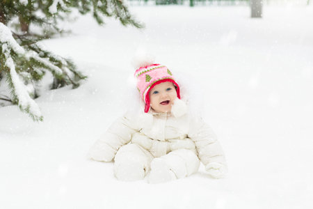 Kids play in snow in winter park. Children playing outdoors on snowy cold day. Boy and girl have fun on sleigh ride. Christmas vacation activity. Outdoor fun by winter weather. Travel with child.の写真素材