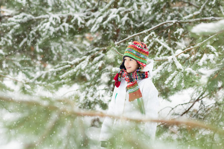 Kids play in snow in winter park. Children playing outdoors on snowy cold day. Boy and girl have fun on sleigh ride. Christmas vacation activity. Outdoor fun by winter weather. Travel with child.の写真素材