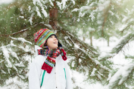 Kids play in snow in winter park. Children playing outdoors on snowy cold day. Boy and girl have fun on sleigh ride. Christmas vacation activity. Outdoor fun by winter weather. Travel with child.の写真素材