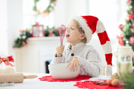 Family baking Christmas cookies. Grandmother and child bake gingerbread pastry. Kids Xmas fun. Little boy in Santa hat making dough for winter cookies. Home holiday decoration.の写真素材