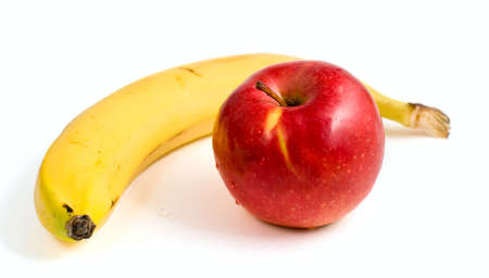 yellow banana and ripe red apple isolated on a white background の写真素材