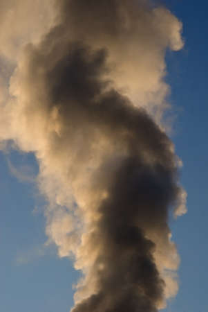column of smoke in front of blue skyの写真素材