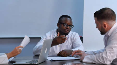 Multiracial group of doctors having discussion in office. Professional shot in 4K resolution. 085. You can use it e.g. in your commercial video, business, presentation, broadcast video.の写真素材