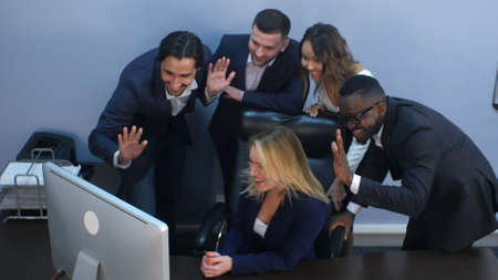 Group of multiracial business people looking at a screen of laptop, having video conference. Top view. Professional shot in 4K resolution. 085. You can use it e.g. in your commercial video, business, presentation, broadcast video.の写真素材