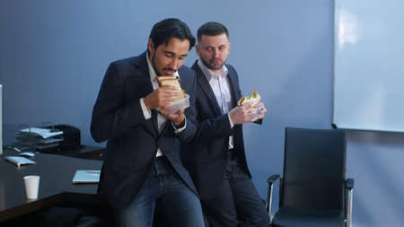 Office workers have a break from work to eat second breakfast. Professional shot in 4K resolution. 085. You can use it e.g. in your commercial video, business, presentation, broadcast video.の写真素材