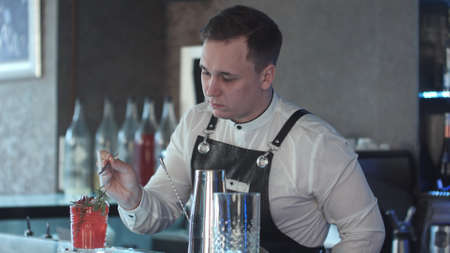 Bartender making and decorating cocktail