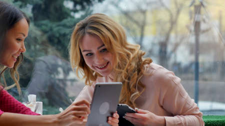 Young beautiful happy women using tablet in cafeの写真素材