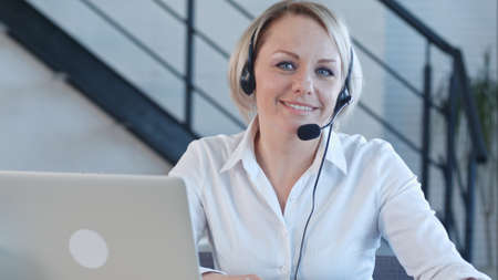 Beautiful business customer service woman smiling talking to a camera in the call centerの写真素材
