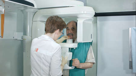 Doctor or radiologist helping senior man doing computer analyzes of teethの写真素材