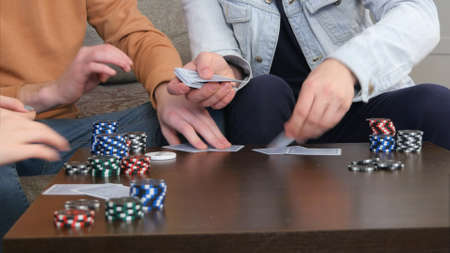 Male hands give out cards on the table in the living roomの写真素材