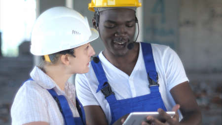 Confident female engineer or architect discussing construction issues with male colleagueの写真素材