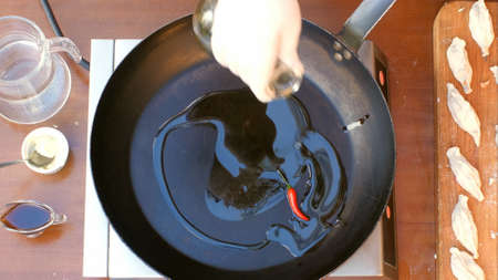 Pouring olive oil over a panの写真素材